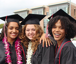 Three women at Chapman graduation on Wilson Field