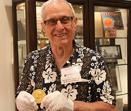 Legacy Society member Dean Wilson holding National Medal of Science at Leatherby Libraries